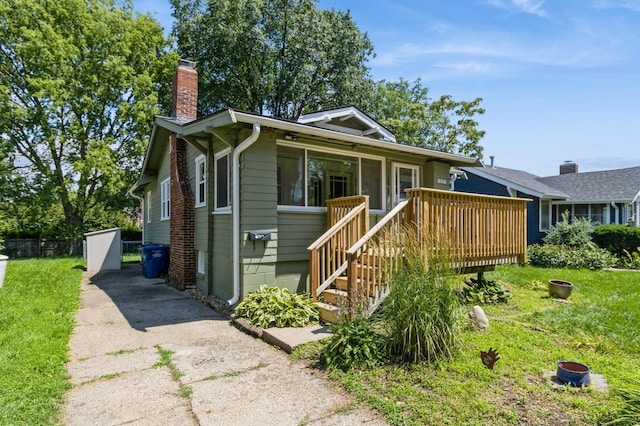 849 39th St, Des Moines, IA 50312 - bungalow-style house with a chimney, a wooden deck, a front lawn, and stairs