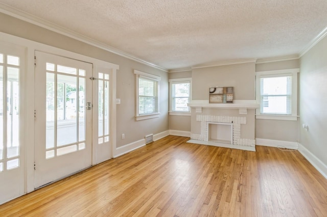 849 39th St, Des Moines, IA 50312 - unfurnished living room featuring a textured ceiling, hardwood / wood-style flooring, crown molding, and a fireplace