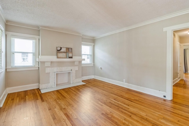 849 39th St, Des Moines, IA 50312 - unfurnished living room with a textured ceiling, light wood-type flooring, ornamental molding, and a brick fireplace