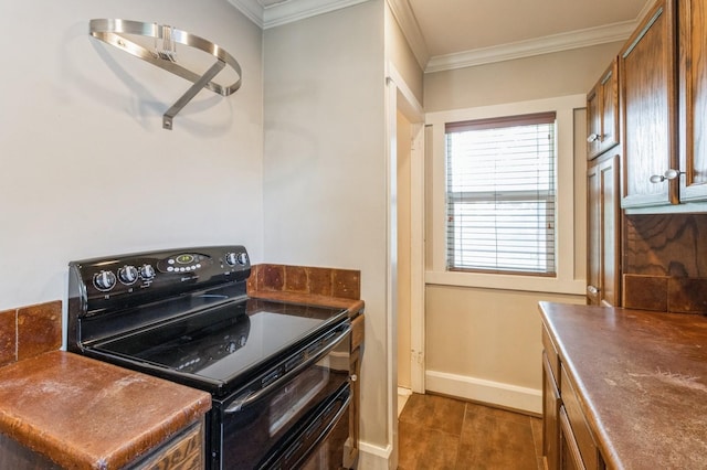 849 39th St, Des Moines, IA 50312 - kitchen featuring electric range, crown molding, dark countertops, and brown cabinetry