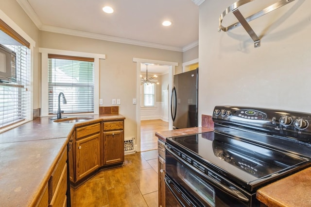 849 39th St, Des Moines, IA 50312 - kitchen featuring electric range oven, freestanding refrigerator, brown cabinetry, crown molding, and a chandelier