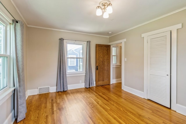 849 39th St, Des Moines, IA 50312 - unfurnished bedroom with light wood-style flooring, ornamental molding, and a closet