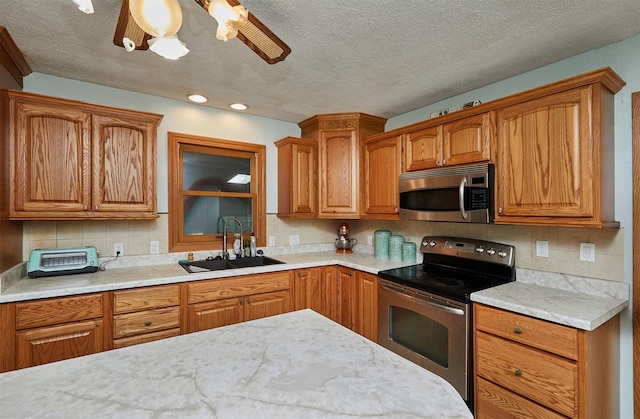 1612 Horse N Buggy Dr, Adel, IA 50003 - kitchen with stainless steel appliances, a textured ceiling, decorative backsplash, brown cabinetry, and recessed lighting