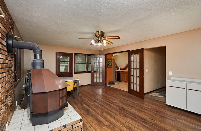 1612 Horse N Buggy Dr, Adel, IA 50003 - living area with a wood stove, french doors, wood finished floors, a ceiling fan, and a textured ceiling