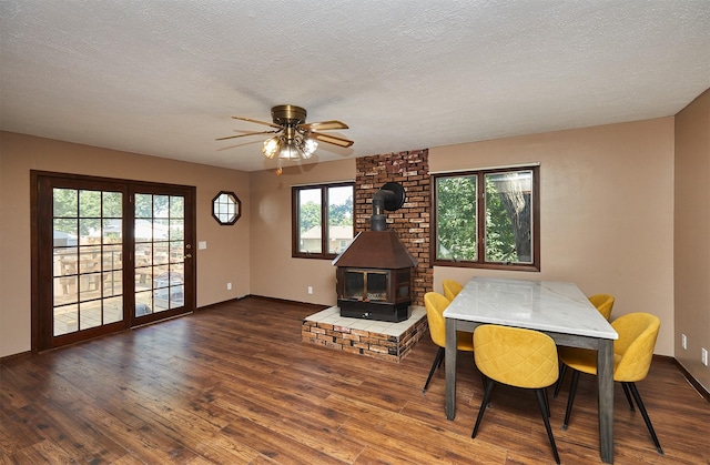 1612 Horse N Buggy Dr, Adel, IA 50003 - dining room featuring a wood stove, wood finished floors, a textured ceiling, and a ceiling fan