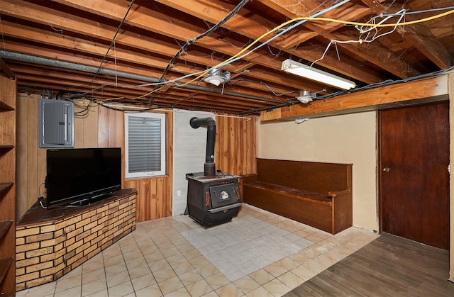 1612 Horse N Buggy Dr, Adel, IA 50003 - unfinished basement featuring electric panel, wood walls, and a wood stove