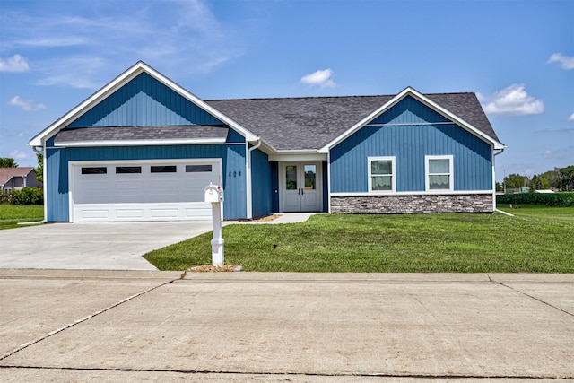 409 S St, Jewell, IA 50130 - ranch-style house with a shingled roof, driveway, a front lawn, an attached garage, and stone siding