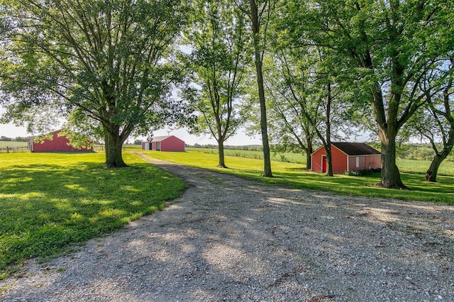 122 G76 Hwy, Lacona, IA 50139 - view of grassy yard featuring driveway, an outbuilding, and a garage