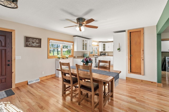 122 G76 Hwy, Lacona, IA 50139 - dining space with a ceiling fan, light wood-style flooring, and a textured ceiling