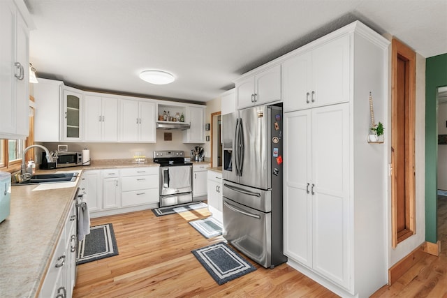 122 G76 Hwy, Lacona, IA 50139 - kitchen featuring stainless steel appliances, light wood-type flooring, light countertops, and white cabinets