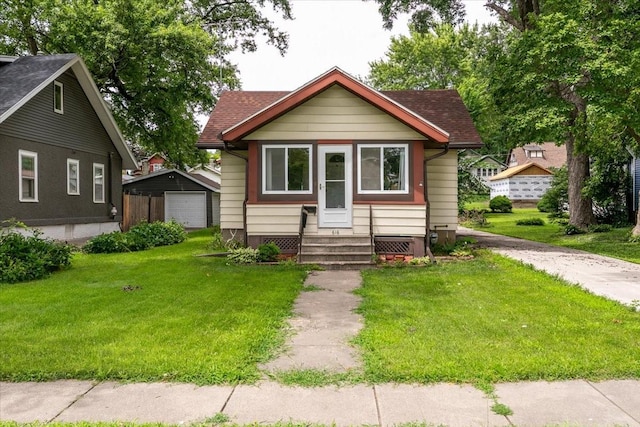 616 4th St, West Des Moines, IA 50265 - bungalow-style home with entry steps, a detached garage, a front lawn, driveway, and an outbuilding