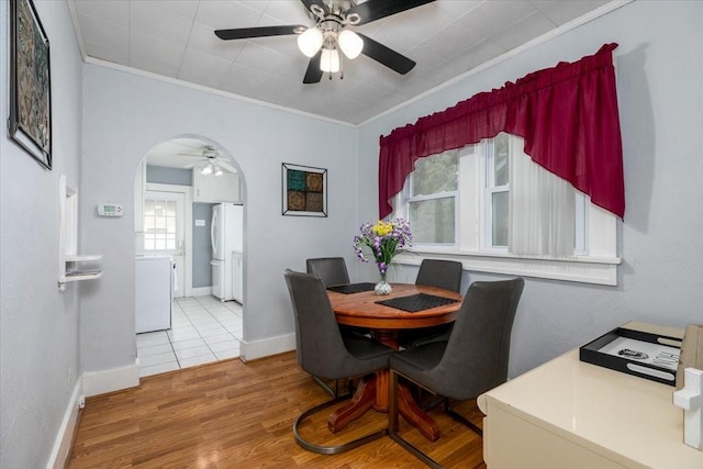 616 4th St, West Des Moines, IA 50265 - dining space featuring ceiling fan, arched walkways, crown molding, and wood finished floors