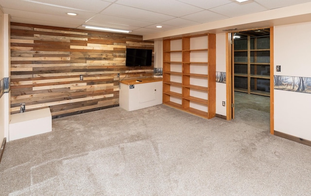702 Jasper Ave NE, Mitchellville, IA 50169 - unfurnished living room featuring carpet, wood walls, recessed lighting, and a paneled ceiling