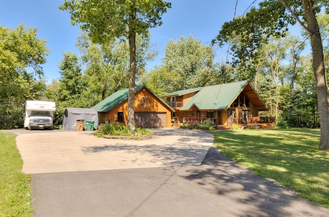 702 Jasper Ave NE, Mitchellville, IA 50169 - view of front of home featuring concrete driveway, a front yard, a metal roof, and log siding