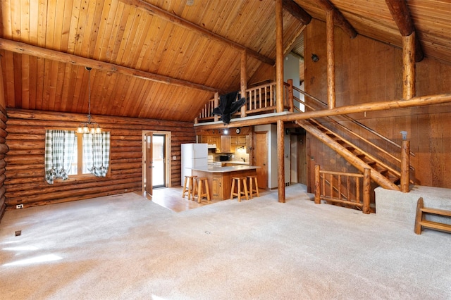702 Jasper Ave NE, Mitchellville, IA 50169 - unfurnished living room with high vaulted ceiling, a chandelier, a wood ceiling with exposed beams, light colored carpet, and log walls