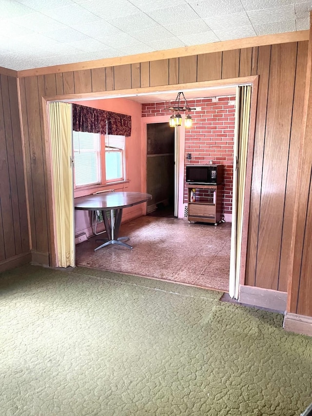 1348 Idaho St, Des Moines, IA 50316 - unfurnished dining area featuring wood walls and carpet floors