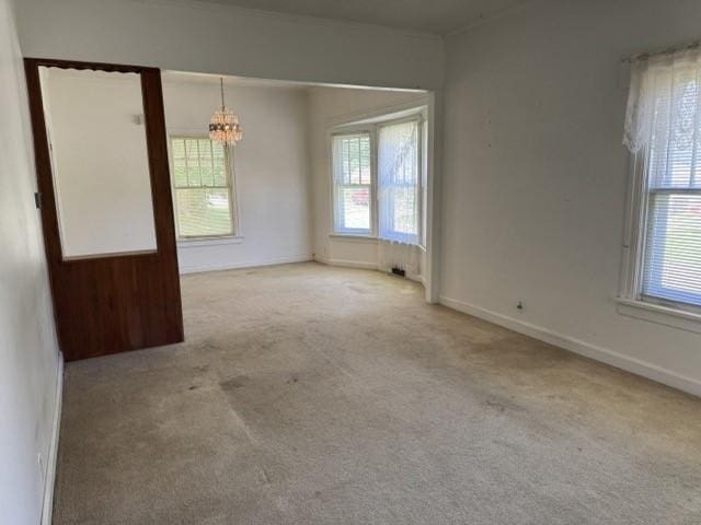 4046 4th St, Des Moines, IA 50313 - carpeted spare room featuring a chandelier and healthy amount of natural light