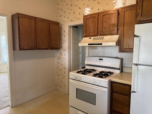 4046 4th St, Des Moines, IA 50313 - kitchen with white appliances, custom exhaust hood, brown cabinetry, light countertops, and light floors