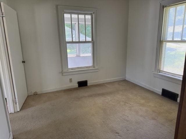 4046 4th St, Des Moines, IA 50313 - empty room with healthy amount of natural light and carpet floors