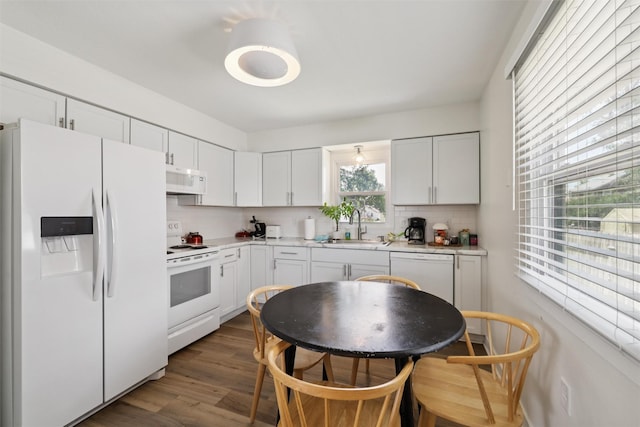 3025 Dean Ave, Des Moines, IA 50317 - kitchen featuring white appliances, decorative backsplash, light countertops, dark wood finished floors, and white cabinets