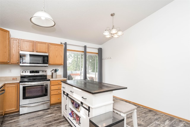 6217 Welker Ave, Des Moines, IA 50312 - kitchen featuring stainless steel appliances, wood finished floors, decorative light fixtures, and a chandelier