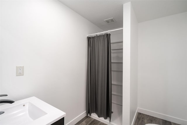 6217 Welker Ave, Des Moines, IA 50312 - full bathroom featuring wood finished floors, a shower with curtain, and vanity