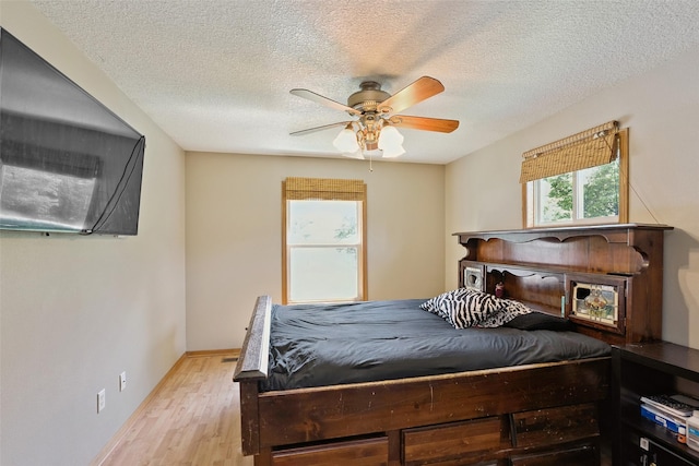 221 E Payton Ave, Des Moines, IA 50315 - bedroom featuring light wood-style floors, a textured ceiling, and ceiling fan