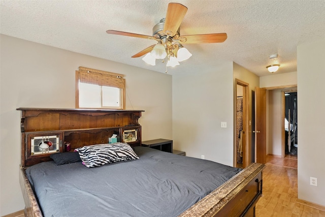 221 E Payton Ave, Des Moines, IA 50315 - bedroom with light wood-style flooring, a textured ceiling, and ceiling fan