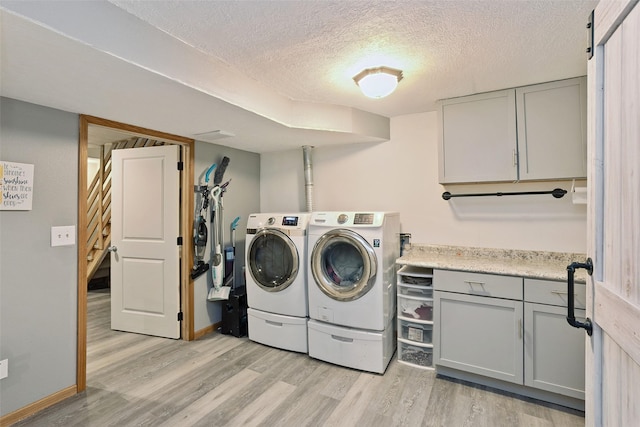 221 E Payton Ave, Des Moines, IA 50315 - washroom with light wood-type flooring, separate washer and dryer, cabinet space, and a textured ceiling