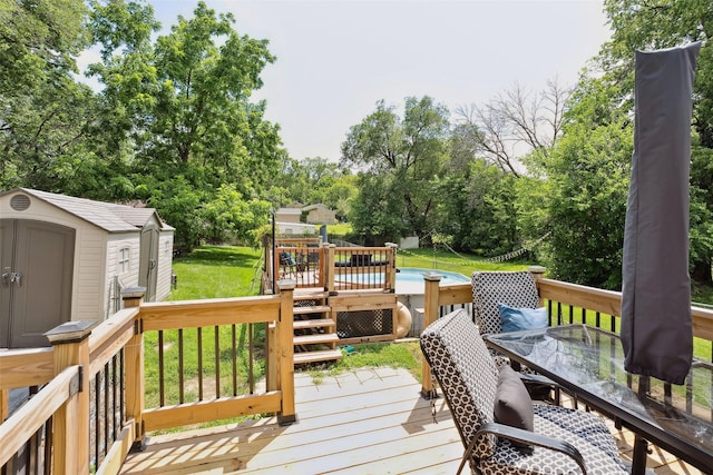 221 E Payton Ave, Des Moines, IA 50315 - wooden terrace with a storage unit, outdoor dining space, a lawn, and view of scattered trees