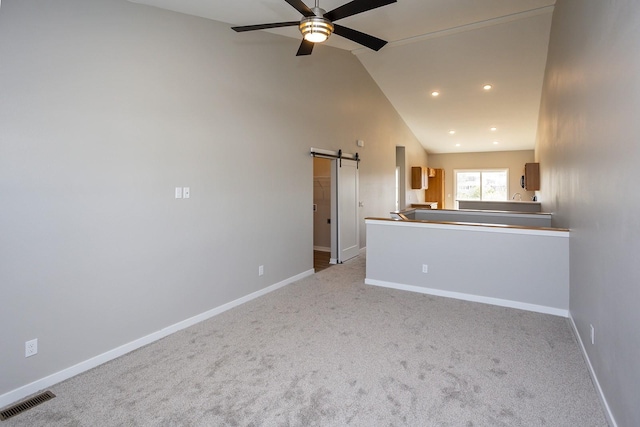 1102 Westview Dr, Huxley, IA 50124 - unfurnished living room featuring a barn door, ceiling fan, carpet floors, lofted ceiling, and recessed lighting