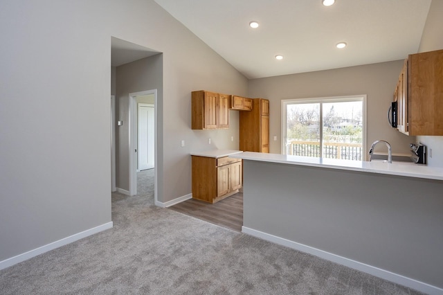1102 Westview Dr, Huxley, IA 50124 - kitchen with carpet, light countertops, lofted ceiling, recessed lighting, and a peninsula