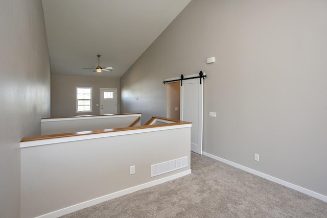 1102 Westview Dr, Huxley, IA 50124 - carpeted empty room with ceiling fan, a barn door, and high vaulted ceiling