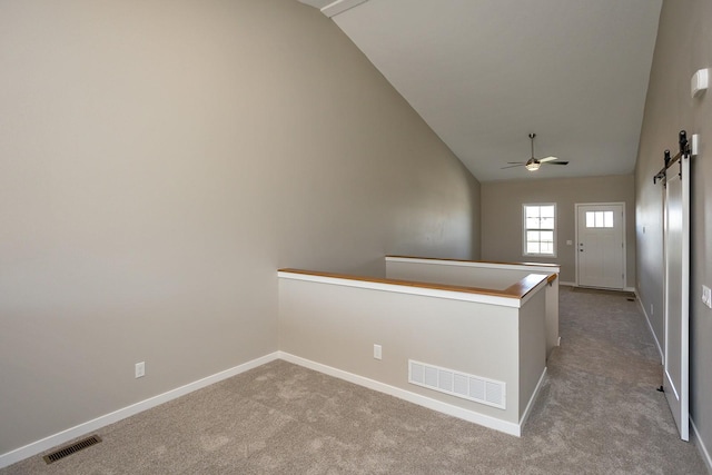 1102 Westview Dr, Huxley, IA 50124 - corridor with lofted ceiling, a barn door, carpet, and an upstairs landing