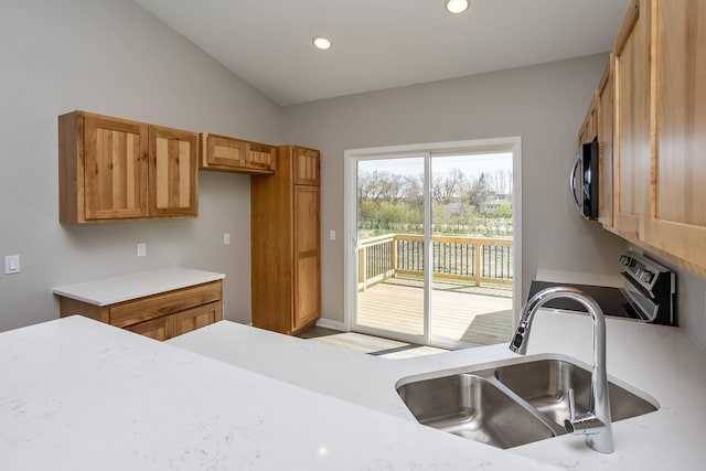 1102 Westview Dr, Huxley, IA 50124 - kitchen with range with electric cooktop, light countertops, recessed lighting, vaulted ceiling, and brown cabinetry