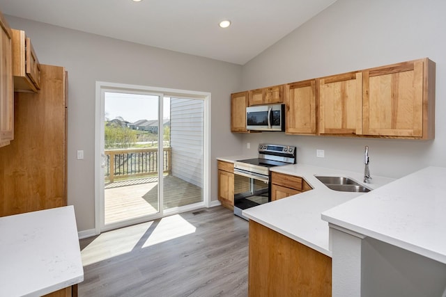 1102 Westview Dr, Huxley, IA 50124 - kitchen featuring appliances with stainless steel finishes, light wood-style flooring, light countertops, vaulted ceiling, and recessed lighting
