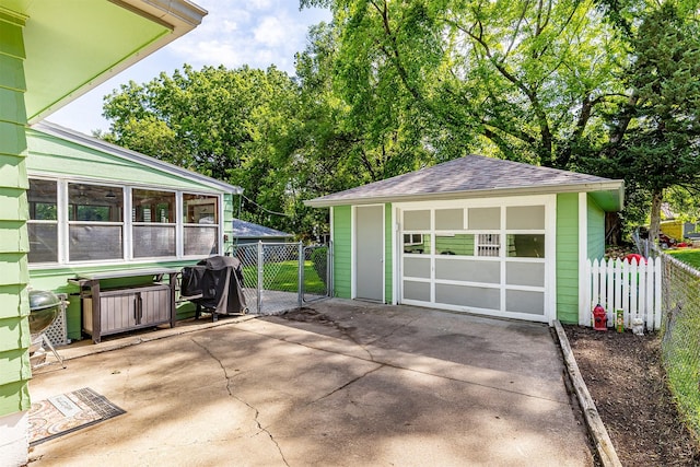 2525 27th Pl, Des Moines, IA 50310 - view of patio / terrace featuring an outdoor structure, a sunroom, a grill, driveway, and a detached garage