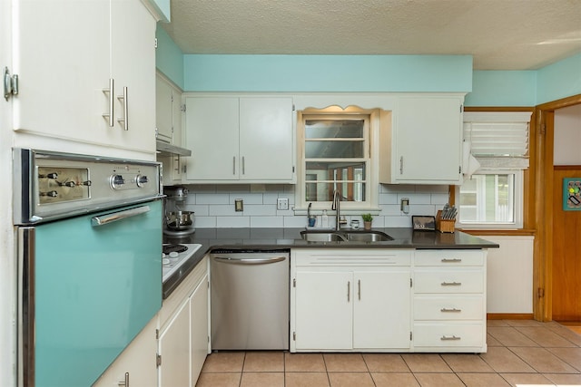 2525 27th Pl, Des Moines, IA 50310 - kitchen with dishwasher, wall oven, dark countertops, light tile patterned floors, and a textured ceiling