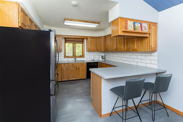 502 5th Ave SW, Altoona, IA 50009 - kitchen with freestanding refrigerator, a peninsula, decorative backsplash, a kitchen breakfast bar, and dishwasher