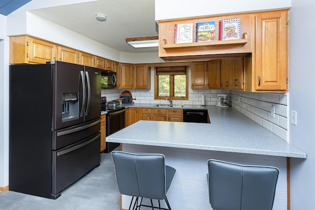 502 5th Ave SW, Altoona, IA 50009 - kitchen featuring black appliances, a peninsula, decorative backsplash, a breakfast bar, and light stone counters