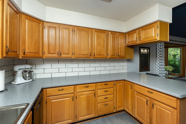502 5th Ave SW, Altoona, IA 50009 - kitchen featuring a peninsula, decorative backsplash, brown cabinetry, and dishwasher