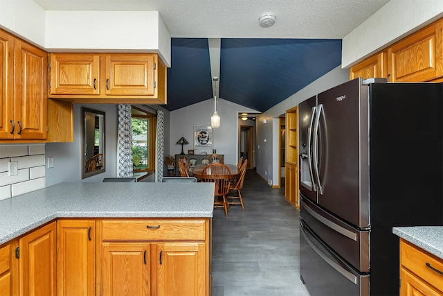 502 5th Ave SW, Altoona, IA 50009 - kitchen featuring stainless steel fridge, lofted ceiling, and brown cabinets