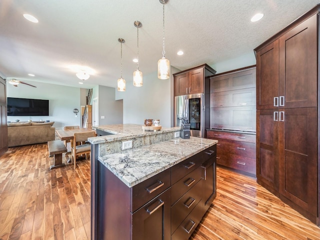 36508 Meadow Ln, Cumming, IA 50061 - kitchen with stainless steel fridge with ice dispenser, light wood-style flooring, a center island, pendant lighting, and recessed lighting