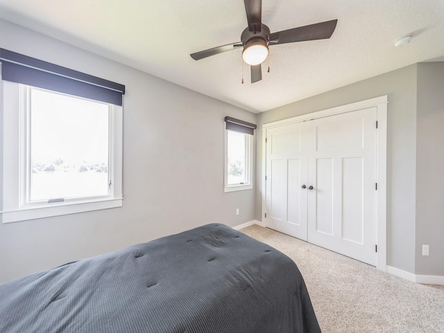 36508 Meadow Ln, Cumming, IA 50061 - bedroom featuring light carpet, a closet, and a ceiling fan