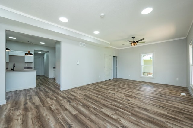 611 W 2nd St S, Newton, IA 50208 - unfurnished living room with dark wood-style floors, a ceiling fan, recessed lighting, and ornamental molding