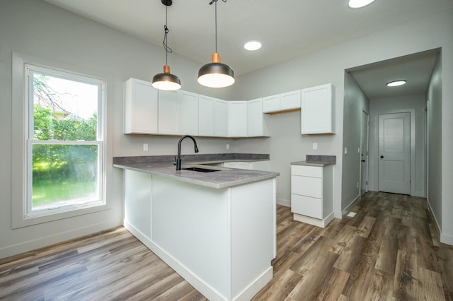 611 W 2nd St S, Newton, IA 50208 - kitchen with a peninsula, white cabinetry, wood finished floors, hanging light fixtures, and recessed lighting
