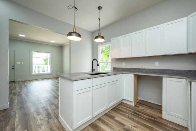 611 W 2nd St S, Newton, IA 50208 - kitchen with a peninsula, white cabinetry, and wood finished floors