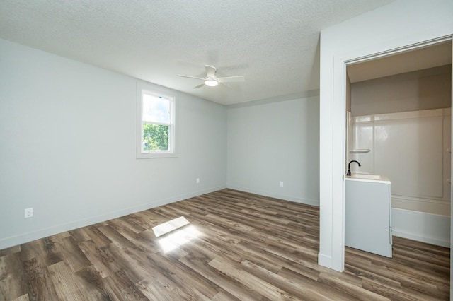 611 W 2nd St S, Newton, IA 50208 - unfurnished bedroom with wood finished floors, a textured ceiling, and a ceiling fan