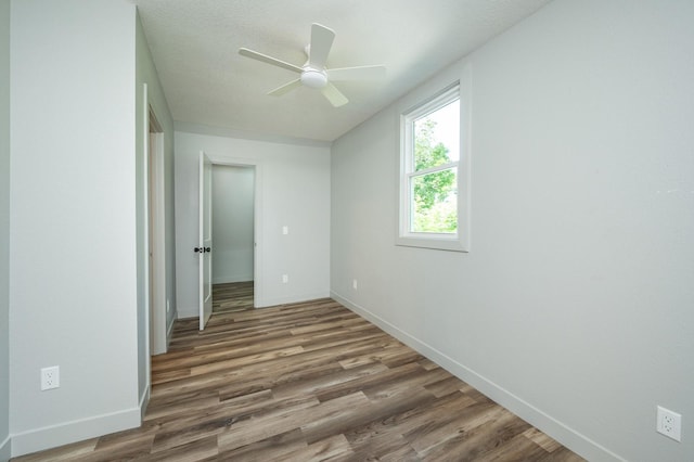 611 W 2nd St S, Newton, IA 50208 - unfurnished bedroom with wood finished floors and a ceiling fan
