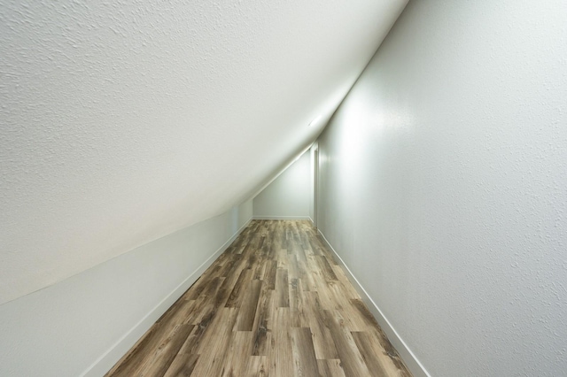 611 W 2nd St S, Newton, IA 50208 - corridor featuring wood finished floors, lofted ceiling, and a textured ceiling